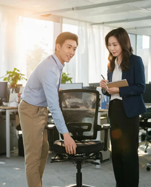 Ergonomic specialist demonstrating chair fit to a procurement manager