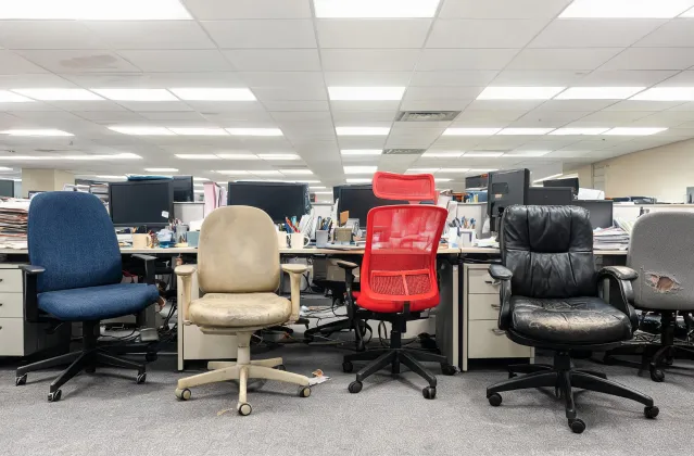 Cluttered office with mismatched chairs and worn-out cushions